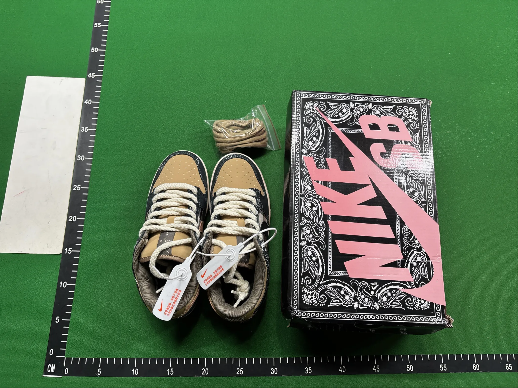 Hipobuy Spreadsheet QC example: USFans photo of tan and black sneakers beside a pink Nike box on a measurement mat